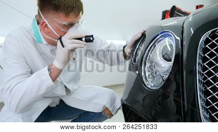 Professional Master After Polishing And Painting Cars, Checks The Flashlight Scratches, A Respirator