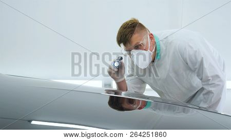 Professional Master After Polishing And Painting Cars, Checks The Flashlight Scratches, A Respirator