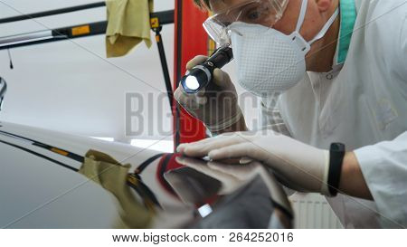 Professional Master After Polishing And Painting Cars, Checks The Flashlight Scratches, A Respirator