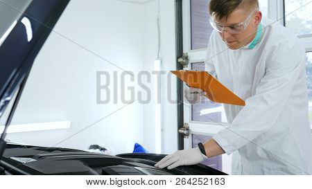 Professional Master After Polishing And Painting Cars, Checks The Flashlight Scratches, A Respirator