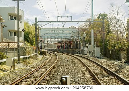 Metal And Stoneware Railroad Tracks And Cityscape On Bight Blusky And Blurry Background Of Crowd Peo