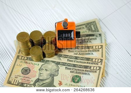 Tally Counter Or Counting Machine With 0000 Number, Coin And Banknote On White Wooden Table, Busines