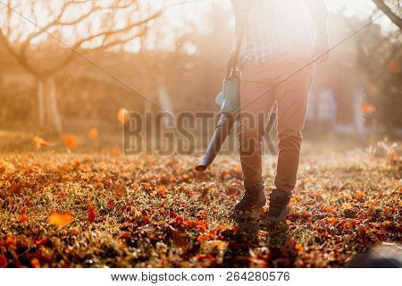 Close Up Details, Portrait Of Gardener Using Leaf Blower And Vacuum. Autumn Clean Up