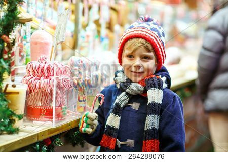 Little Cute Kid Boy Buying Sweets From A Cancy Stand On Christmas Market. Happy Child On Traditional