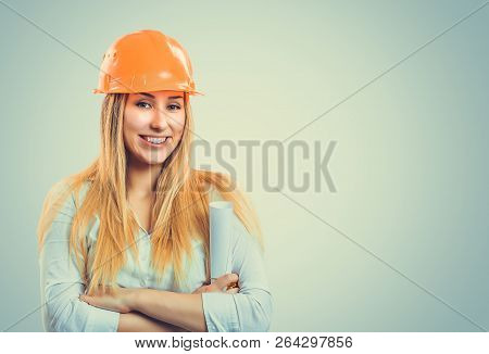 Professional Content Woman In White Shirt Wearing Orange Hardhat And Holding Paper Roll