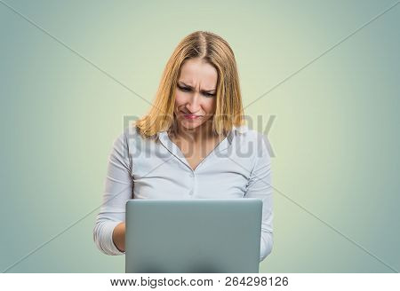 Modern Blond Woman Frowning In Misunderstanding While Using Laptop On Gray Backdrop