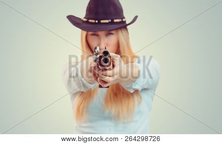 Blurred Woman In Cowboy Hat Aiming At Camera With Double-barreled Gun On Gray Background