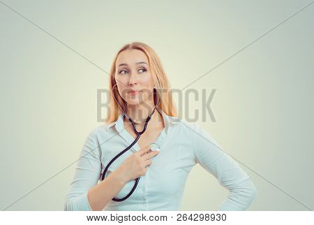 Curious Pretty Woman Listening Heartbeat With Stethoscope While Looking Away
