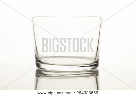Shot Of Glass. Empty Small Glass On A Reflective Surface On White Background.