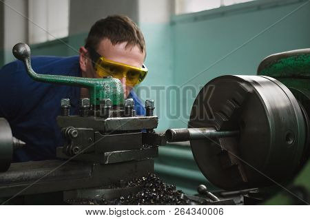 Turner Worker Is Working On A Lathe Machine In A Factory.