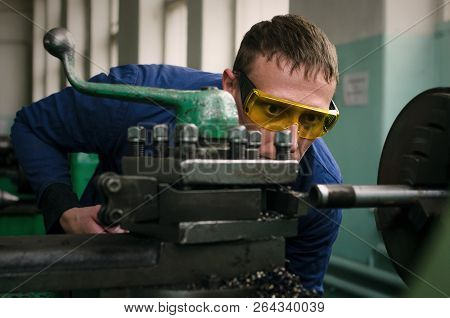 Turner Worker Is Working On A Lathe Machine In A Factory.