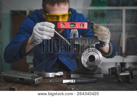 Man Worker Is Working With Iron Detail On Vise Grip On Blacksmith Table.