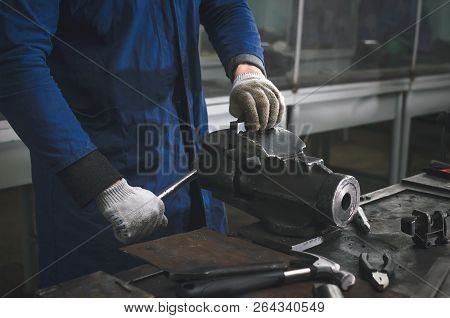Man Worker Is Working With Iron Detail On Vise Grip On Blacksmith Table.