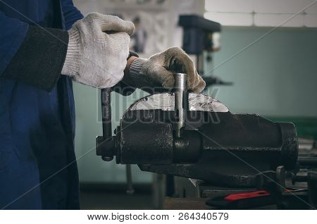 Man Worker Is Working With Iron Detail On Vise Grip On Blacksmith Table.