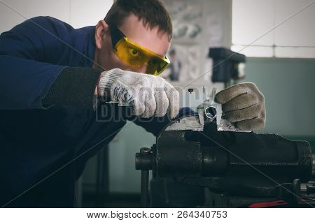 Man Worker Is Working With Iron Detail On Vise Grip On Blacksmith Table And Is Measuring A Diameter 