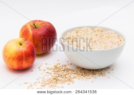 Oatmeal In White Bowl And Red Apple On White Background. Isolated On White. Healthy Food