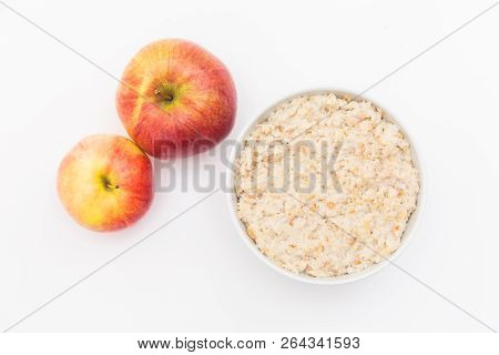 Oatmeal In White Bowl And Red Apple On White Background. Isolated On White. Healthy Food
