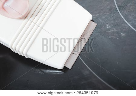 Cleaning A Ceramic Glass Cooktop With A Glass Scraper