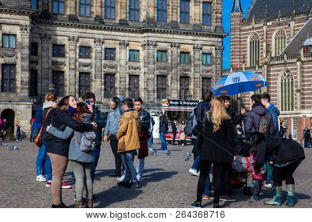Amsterdam, Netherlands - March, 2018: Tourists At The Royal Palace Of Amsterdam Located At Dam Squar