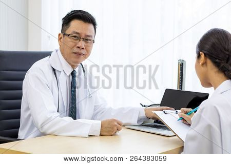 Two doctors in the hospital discuss the diagnos of the patient