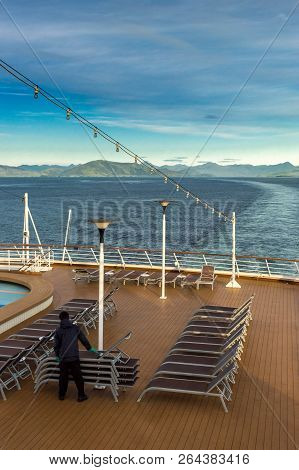 Inside Passage, Bc, Canada - September 13, 2018: Cruise Ship Worker Stacking Outdoor Loungers In The