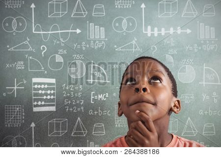 Maths against thoughtful boy against greenboard in classroom