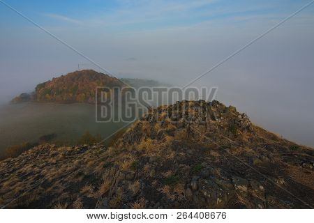 The Rocky Peak With Daybreak. Full Moon Night Ends And Sun Appeared In Mist Above Hilly Horizon