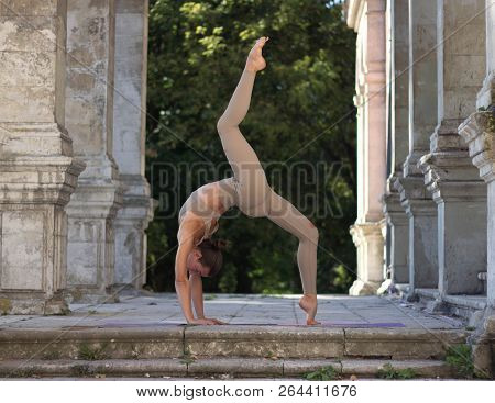 Girl Doing Backbend Between The Columns Near The Castle