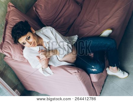 Beautiful pregnant woman sitting on sofa at home