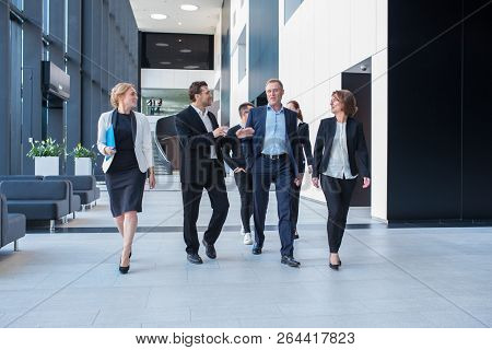 Lively Business Team Walking Together In Office Builging Showing Teamwork, Togetherness And Liveline