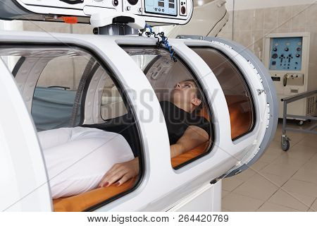 Girl Patient Lying In A Hyperbaric Chamber.