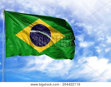 National Flag Of Brazil On A Flagpole In Front Of Blue Sky