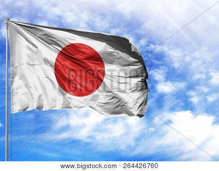 National Flag Of Japan On A Flagpole In Front Of Blue Sky