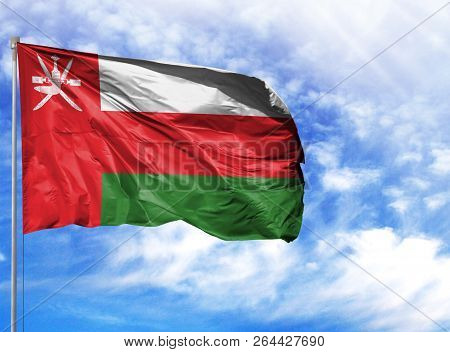 National Flag Of Oman On A Flagpole In Front Of Blue Sky