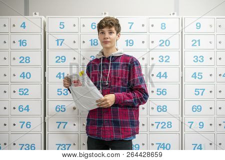 Happy Young Teenager Holding Recieved Mail Package With New Clothes Inside The Post Office