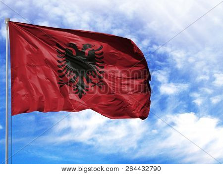 National Flag Of Albania On A Flagpole In Front Of Blue Sky