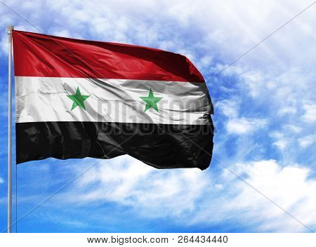 National Flag Of Syria On A Flagpole In Front Of Blue Sky