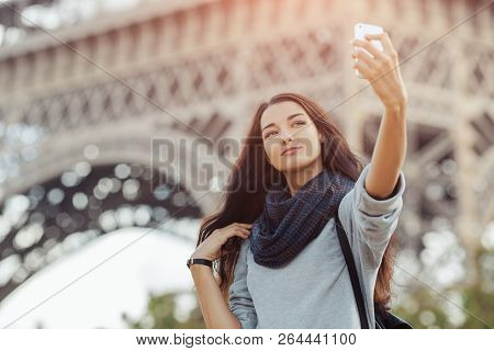 Happy Travel Woman Taking Funny Selfie With Her Mobile Phone Near The Eiffel Tower, Paris. Portrait 