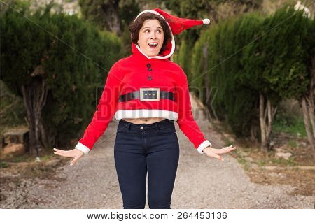 Christmas, Holidays, Humor And People Concept - Funny Happy Woman In Santa Suit Dancing Outdoors