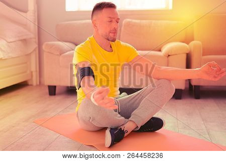 Nice Handsome Man Meditating In The Room