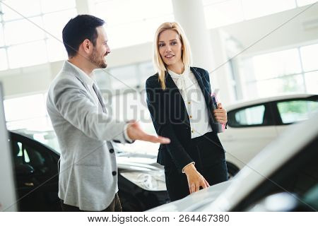 Handsome Salesman At Car Dealership Selling Vehichles