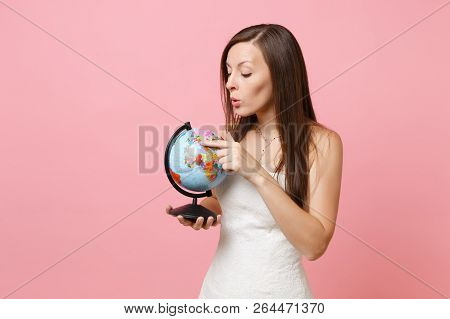 Portrait Of Curious Bride Woman In Lace White Wedding Dress Pointing Index Finger On World Globe, Ch
