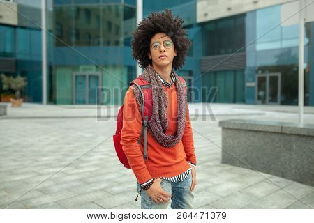Young Fashionable Dressed Curly Black African American With Glasses Walks Through The Streets Agains