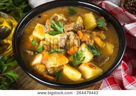 Goulash With Meat And Vegetables In Black Bowl. Beef Stew With Vegetables. European Cuisine.