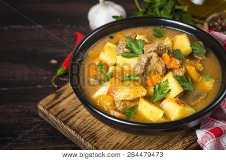 Goulash With Meat And Vegetables In Black Bowl. Beef Stew With Vegetables. European Cuisine.