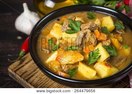 Goulash With Meat And Vegetables In Black Bowl. Beef Stew With Vegetables. European Cuisine.