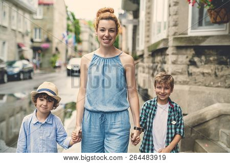 Mother With Her Two Son Outside In An Urban Street