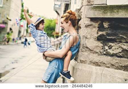 Mother With Her Son Outside In An Urban Street