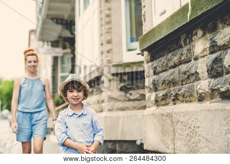 Mother With Her Son Outside In An Urban Street