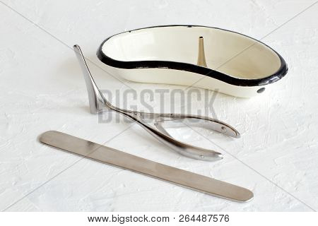 Ear Funnel In Metal Kidney-shaped Bath, Metal Spatula, Vienne Nose Mirror On White Concrete Backgrou
